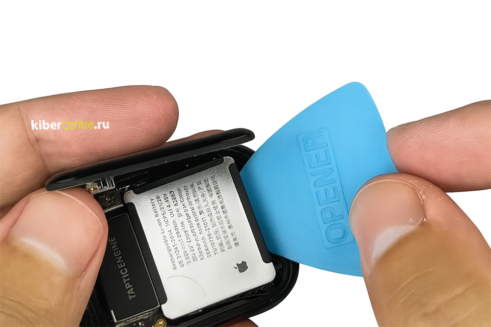 С помощью медиатора специалист поддевает аккумулятор Эппл Вотч
